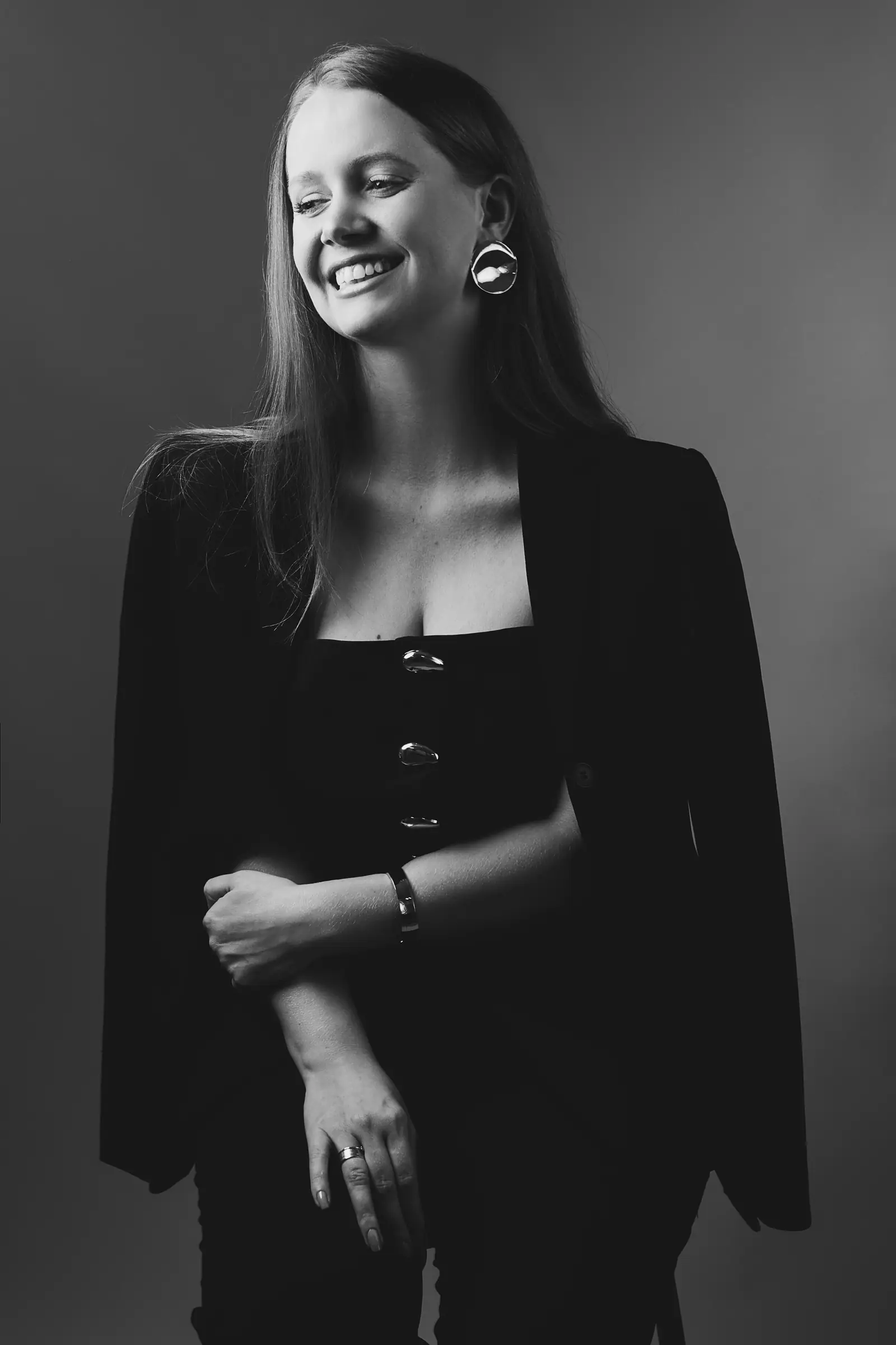 Retrato em preto e branco de mulher de vestido com botões, sorrindo